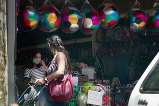 De máscara, mulher carrega carrinho de bebê no Centro da Capital. (Foto: Marcos Maluf)
