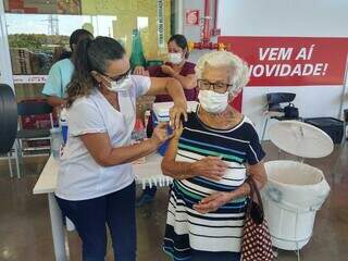 Idosa sendo vacinada em posto itinerante de Campo Grande. (Foto: Cleber Gelio)