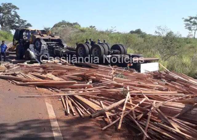 Motorista perde controle e tomba caminh&atilde;o carregado com madeira