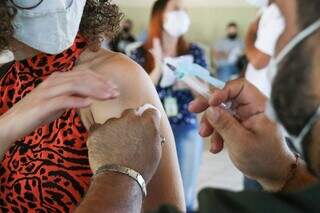 Moradora sendo imunizada contra a covid-19 na Capital. (Foto: Henrique Kawaminami)