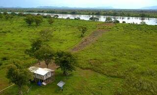 Imagem aérea de casa de família pantaneira às margens do Rio Paraguai com placa de energia solar. (Foto: Chico Ribeiro)