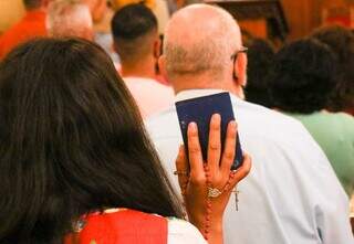Momento de oração de fiel durante a missa das Cinzas. (Foto: Henrique Kawaminami)