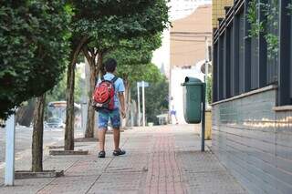 Aluno com mochila nas costas a caminho da escola na Capital. (Foto: Henrique Kawaminami) 
