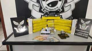 Drogas, dinheiro e balança de precisão apreendida com os suspeitos. (Foto: Polícia Civil)