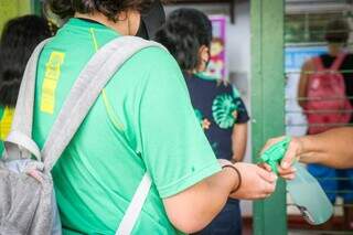 Estudante da rede estadual higieniza as mãos antes de entrar na escola. (Foto: Henrique Kawaminami)