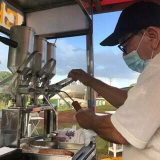 Vendedor prepara um dos churros para cliente. (Foto: Jéssica Fernandes)