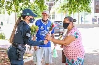 Policial Militar entrega rosa para idosa que passava pelo Centro. (Foto: Henrique Kawaminami)