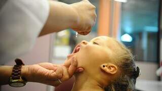 Criança recebendo a vacina em gotinhas contra a poliomielite. (Foto: Prefeitura de Campo Grande)