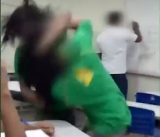 Professor aparece apagando quadro enquanto alunas brigam em sala de aula. Foto: Reprodução