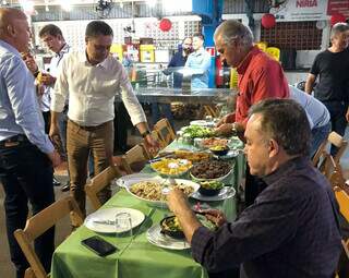 Na mesa, Vander Loubet degusta sobá e em pé, governador Reinaldo Azambuja escolhe o que vai comer. (Foto: Direto das Ruas)