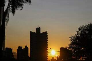 Sol visto entre prédios do Jardim dos Estados, na Capital, nesta manhã. (Foto: Henrique Kawaminami)