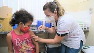 Menina recebe dose da vacina contra covid em unidade de saúde da Capital. (Foto: PMCG)