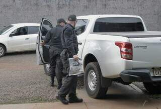 Integrantes do Gaeco chegando com arma apreendida à sede do Garras, após dia de buscas. (Foto: Paulo Francis)