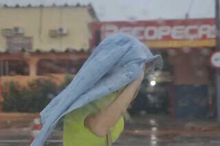 Mulher se protegendo da chuva desta manhã na Capital. (Foto: Paulo Francis)