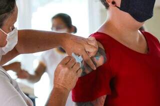Moradora sendo vacinada contra a covid-19 na Capital. (Foto: Henrique Kawaminami) 