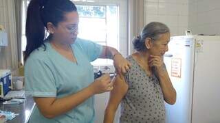 Profissional de saúde vacina idosa em unidade de saúde da Capital. (Foto: PMCG)