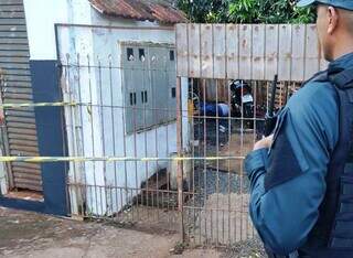 Policial observa local onde rapaz foi executado nesta terça-feira em Dourados (Foto: Adilson Domingos)