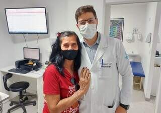 Romilda ao lado do médico que integra a equipe de oftalmologia do hospital. (Foto: Assessoria Santa Casa)