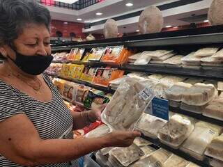 Professora aposentada Eloina Yanez Brites, de 72 anos, escolhendo bacalhau em supermercado da Capital. (Foto: Caroline Maldonado)