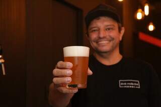 Leandro segura uma das cervejas artesanais servidas no bar. (Foto: Kísie Ainoã)