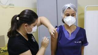 Profissionais de saúde aplicando e recebendo dose da vacina contra covid. (Foto: PMCG)