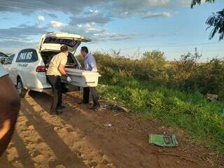 Agentes funerário recolhendo corpo de Felipe encontrado ontem à tarde em área de mata (Foto: Gabrielle Tavares) 