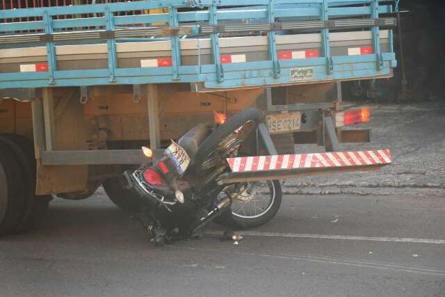 Motociclista tenta ultrapassagem e vai parar debaixo de caminh&atilde;o 