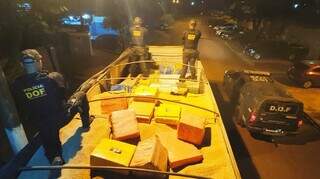 Policiais do DOF sobre caminhão que transportava droga em carga de farelo de soja. (Foto: Divulgação)