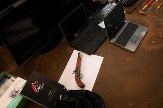Arma, notebooks e outros objetos recuperados pela polícia. (Foto: Henrique Kawaminami)