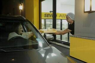 Pizza é entregue aos clientes em drive-thru. (Foto: Kísie Ainoã)