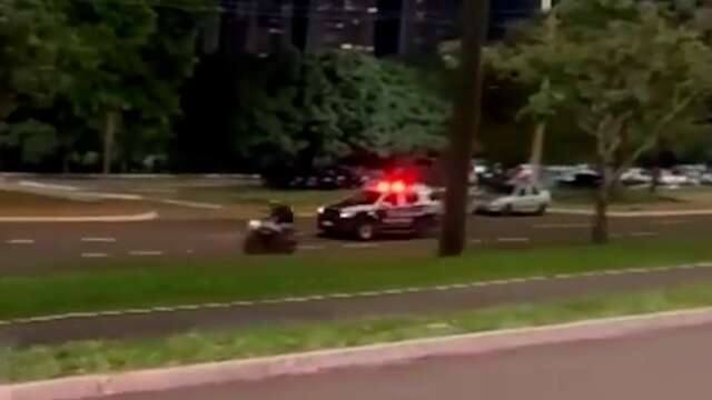 Motociclista passa em alta velocidade ao lado de viatura da PM