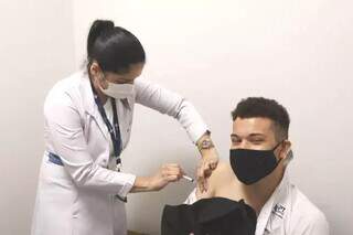 Jovem recebendo dose de vacina contra gripe em Campo Grande. (Foto: Divulgação)