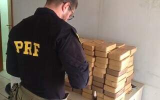 Polícia Rodoviária Federal pesando tabletes da droga. (Foto: Divulgação | PRF)