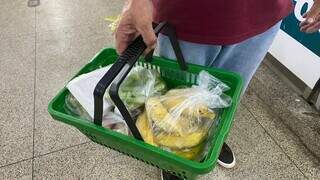 Cliente segurando cesta de mercado com verduras. (Foto: Karine Alencar)