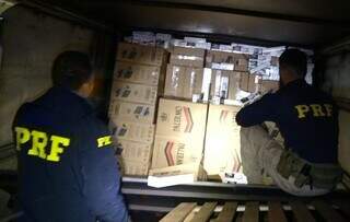 Policiais descarregando as caixas dos produtos. (Foto: PRF) 