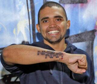 Cansado do povo que detona o bairro, Cris tatuou "Nhanhá" no braço 