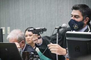 Juiz Carlos Alberto Garcete mostra a arma usada no crime. (Foto: Henrique Kawaminami)