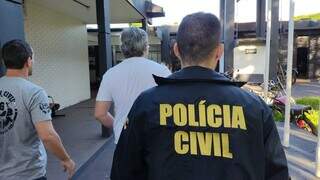 Marcos sendo conduzido por policiais civis após ser preso ontem em Dourados (Foto: Adilson Domingos)