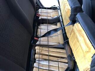 Dezenas de tabletes encontrados sob o banco traseiro do carro. (Foto: PMR) 