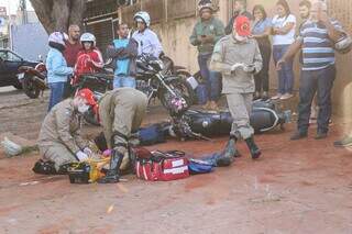 Moto caída e bombeiros atendendo Adriano, que foi atingido por bala perdida. (Foto: Henrique Kawaminami)
