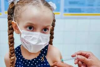 Criança recebendo dose de vacina contra covid-19 em Campo Grande (Foto: Divulgação)