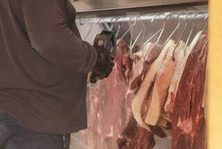 Açougueiro mostra cortes de carnes bovinas ideais para churrasco em estabelecimento na periferia da Capital. (Foto: Cleber Gellio)