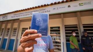 Em busca de emprego, homem mostra carteira de trabalho. (Foto: Divulgação)