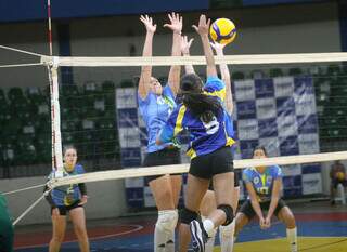 Meninas disputam a bola em jogo da Copa Pantanal de Vôlei. (Foto: Divulgação)