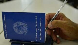 Pessoa assinando carteira de trabalho (Foto: Divulgação | Governo de MS)