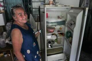 Maria Elsa abre a geladeira esvaziada e não tem certeza sobre o que o alimento de amanhã. (Foto: Marcos Maluf)