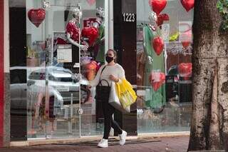 Mulher passa em frente de vitrine de loja decorada para Dia dos Namorados. (Foto: Arquivo)