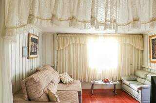 São duas cortinas de renda que proporcinam o charme da sala, que parece de casinha de boneca. (Foto: Henrique Kawaminami)