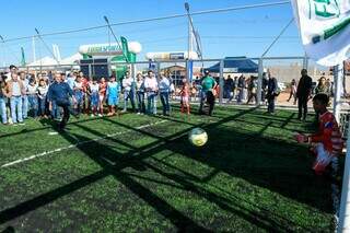 Governador Reinaldo Azambuja chuta bola em quadra de futebol society da arena inaugurada hoje em Chapadão do Sul. (Foto: Bruno Rezende/Governo MS)