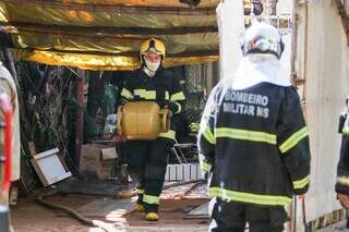 Bombeiro retira botijão de gás de dentro de residência. (Foto: Henrique Kawaminami)